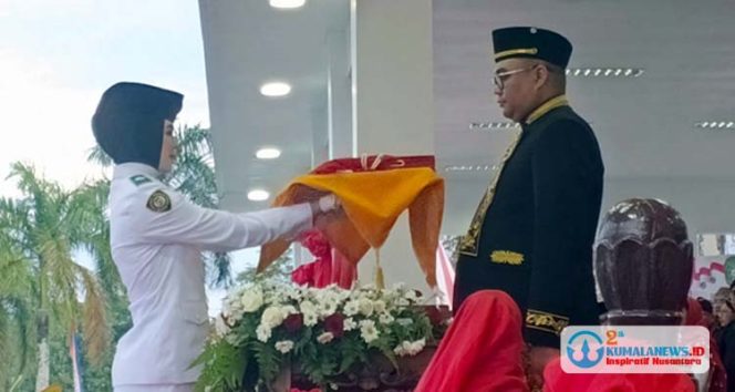 
 Bupati Kutai Kartanegara Aulia Rahman Basri, selaku inspektur upacara menerima duplikat bendera merah putih. (Indirwan/fairuzzabady/Kumalanews.id)