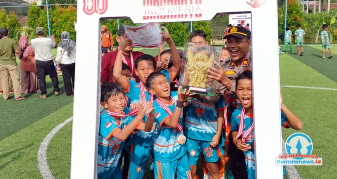 
 Kapolsek Tenggarong, Iptu Boedi Santoso, menyerahkan piala kepada juara 1 kategori pemenang gold mini turnamen sepak bola usia dini bertajuk Polsek Tenggarong Cup, dalam rangka memeriahkan HUT Kemerdekaan RI ke-80, pada Minggu (24/8/2025) di lapangan Setia Mini Soccer Tenggarong. (Indirwan/Fairuzzabady/Kumalanews.id)