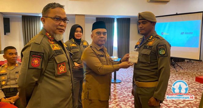 
 Asisten I Setkab Kutai Kartanegara, Akhmad Taufik Hidayat, didampingi Kepala Satpol PP Kukar, Arfan Boma, mengalungkan tanda peserta pelatihan penanganan huru-hara sebagai tanda dimulainya kegiatan. (Fairuzzabady/Kumalanews.id)
