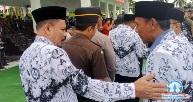 
 Momen Pelaksana Tugas Sekretaris Dinas Pendidikan dan Kebudayaan Kabupaten Kutai Kartanegara, Pujianto, saat memberikan ucapan selamat kepada para guru yang menerima apresiasi atas prestasi mereka.