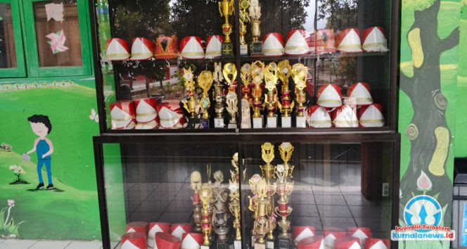 
 Deretan piala dan topi baris-berbaris terpajang di ruang trofi SDN 012 Tenggarong, sebagai bukti berbagai prestasi siswa baik di bidang akademik maupun kegiatan ekstrakurikuler.