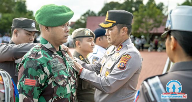 
 Kapolres Kutai Kartanegara, AKBP Khairul Basyar, menyematkan pita kepada personel TNI dan aparat terkait sebagai tanda resmi dimulainya Operasi Zebra Mahakam 2025 di Kutai Kartanegara, Senin (17/11/2025). (Dok. Humas Polres Kukar)