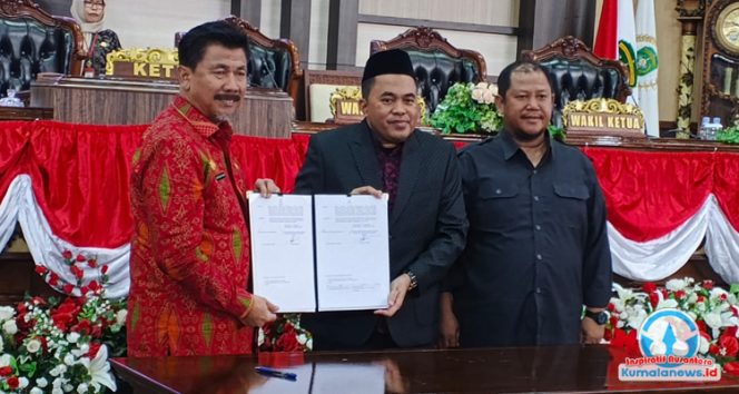 
 Sekretaris Daerah Kutai Kartanegara, Sunggono, bersama Ketua DPRD Kukar, Ahmad Yani, didampangi Wakil Ketua DPRD Kukar, Abdul Rasid menunjukkan dokumen kesepakatan usai penandatanganan dalam Rapat Paripurna Pembahasan Rancangan Peraturan Daerah yang digelar di Ruang Sidang Utama DPRD Kukar, pada Jumat (7/11/2025).